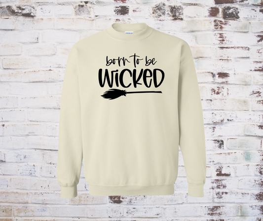 Sand-colored sweatshirt with the phrase “Born to Be Wicked” printed alongside a broom design.