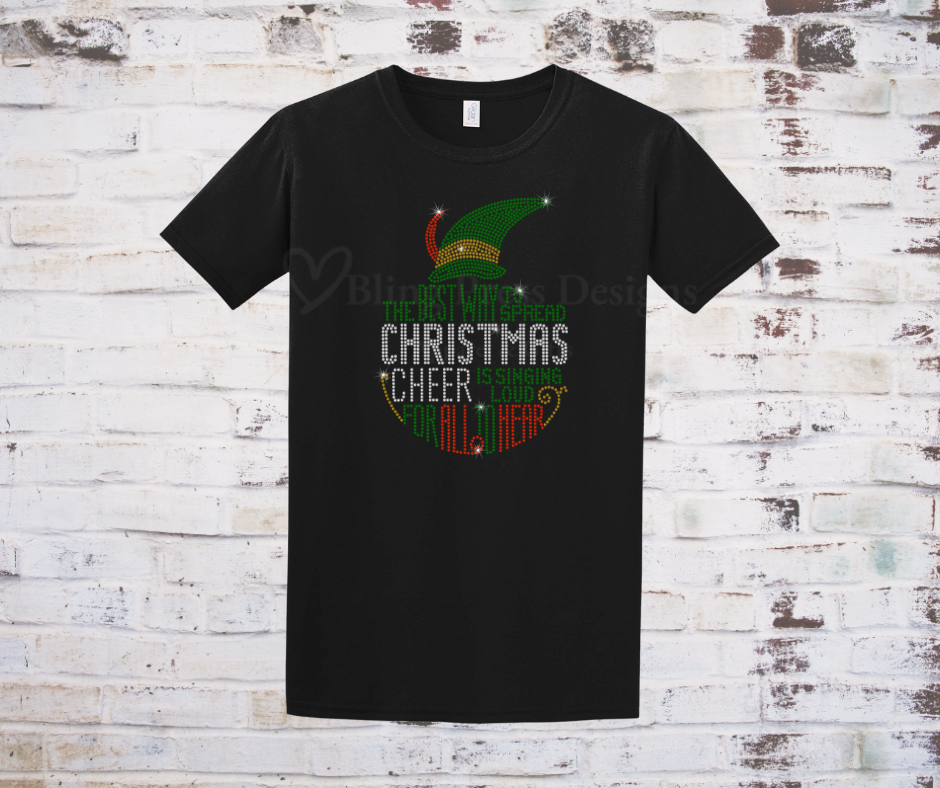 A festive black T-shirt featuring a sparkling rhinestone design of a cheerful Christmas elf, accented with holiday-themed details. The bling embellishments catch the light, adding a glamorous touch to the holiday spirit.