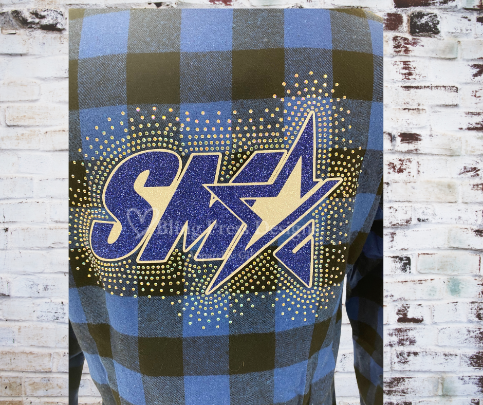 Close up of A SMA Flannel Long Sleeve Shirt featuring a glitter vinyl SMA logo and a sparkling rhinestone spray design. Made from soft, high-quality flannel for a stylish and comfortable look, perfect for layering and showcasing school spirit.