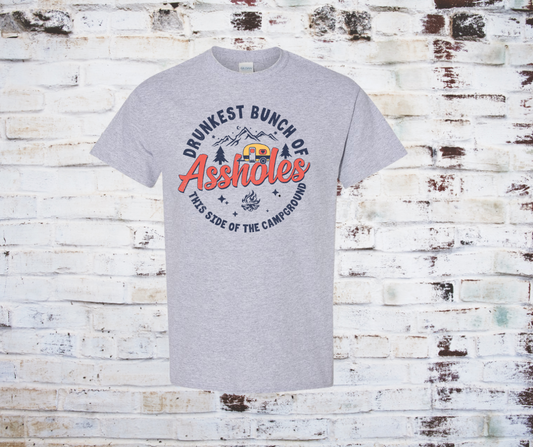 A printed tee featuring the phrase 'Drunkest Bunch of Assholes This Side of the Campfire' in bold lettering, perfect for camping and bonfire gatherings.