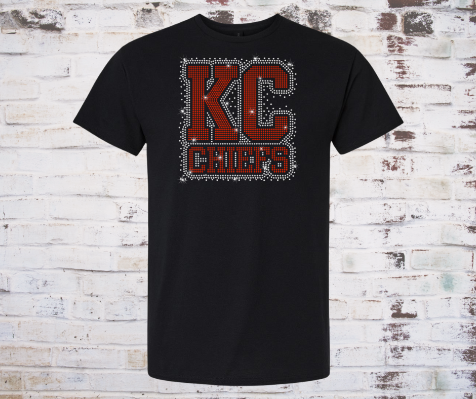 Shirt covered in sparkling rhinestones featuring a full KC Chiefs scatter design. The red, gold, and clear rhinestones shimmer across the entire shirt, creating a bold and eye-catching game day look full of team spirit.