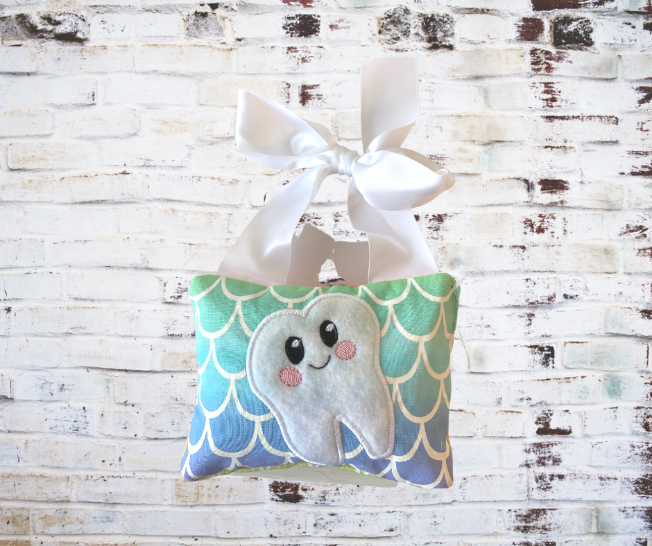 A **Handmade Fabric Tooth Fairy Pillow**, featuring a small pocket for placing lost teeth, crafted from soft, high-quality fabric with charming details. A functional and magical keepsake for children.