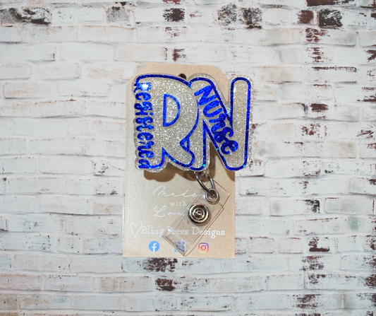 A handmade glitter badge reel with an interchangeable top, featuring a retractable cord and secure clip, perfect for adding sparkle and personality to work attire.