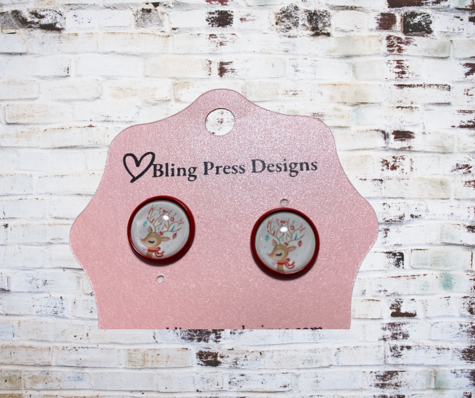 Pair of earrings on a Bling Press Designs card against a textured white background
