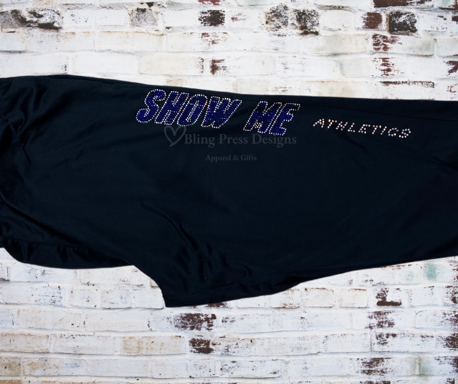 Close up rhinestone-accent on sleek leg warm-up pants, showcasing the stylish embellishment