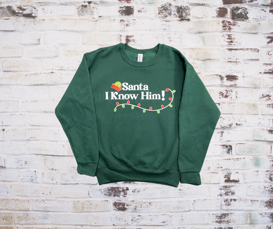 Green Christmas sweatshirt with the festive phrase “Santa I Know Him” printed on the front.