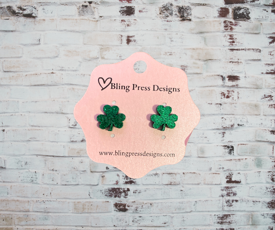 A pair of glitter shamrock acrylic stud earrings with a sparkling finish, lightweight and comfortable, perfect for St. Patrick's Day or adding a festive touch to any outfit.