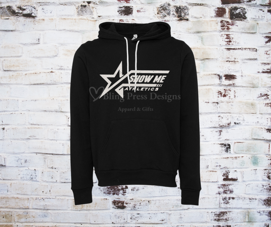 A black soft and cozy hoodie featuring a white glitter "Show Me" logo, designed with a relaxed fit, front pocket, and adjustable drawstring hood.