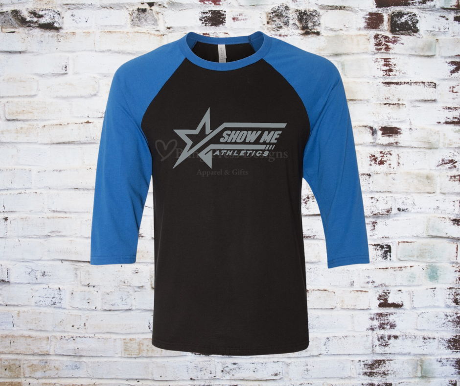 A black Show Me Athletics Logo 3/4 Sleeve Raglan Tee, featuring the bold Show Me Athletics logo with blue contrasting 3/4 sleeves for a sporty, stylish look.