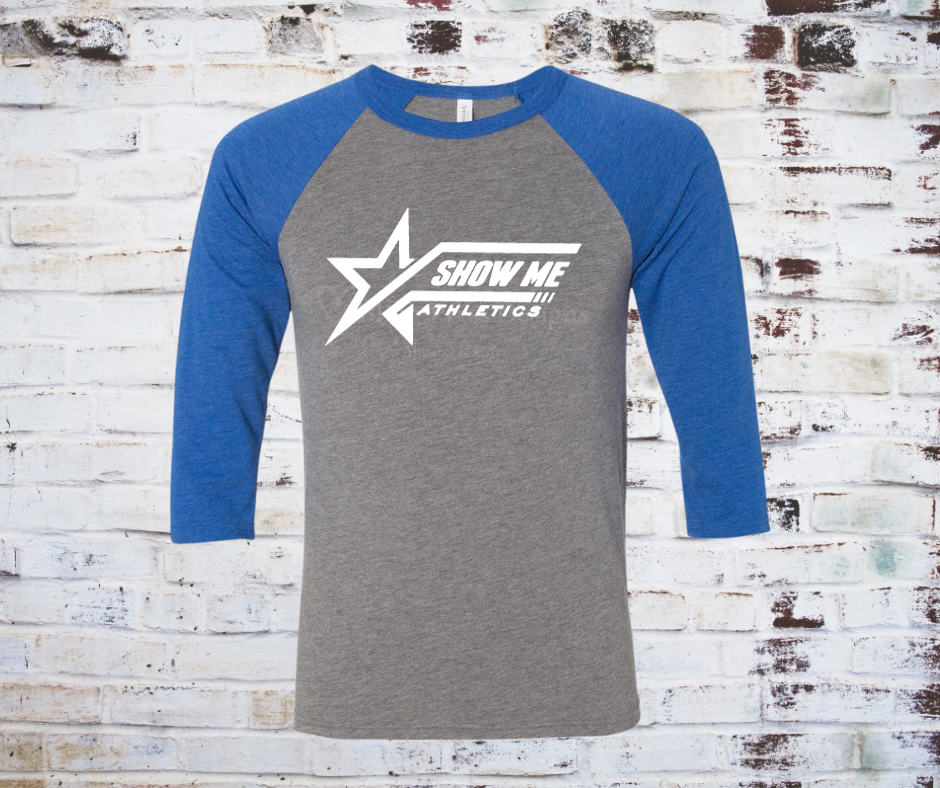 A grey Show Me Athletics Logo 3/4 Sleeve Raglan Tee, featuring the bold Show Me Athletics logo with blue contrasting 3/4 sleeves for a sporty, stylish look.