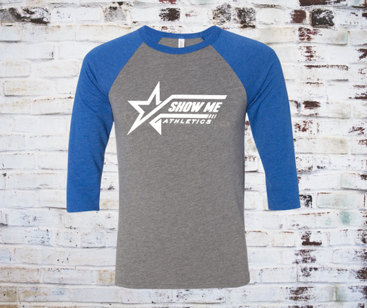 A grey Show Me Athletics Logo 3/4 Sleeve Raglan Tee, featuring the bold Show Me Athletics logo with blue contrasting 3/4 sleeves for a sporty, stylish look.