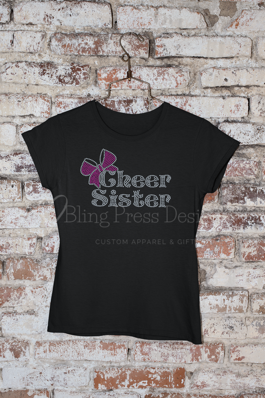 'Cheer Sister' rhinestone design with a sparkling bow accent on a soft, comfortable tee