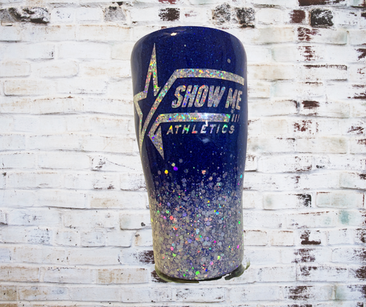 "Glitter tumbler with a high-shine epoxy finish and prominently displayed Show Me Athletics logo.