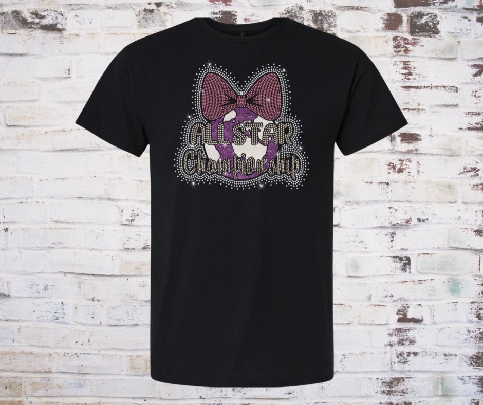 Black T-shirt featuring a rhinestone “All Star World Championship” design with a pink cheer bow and sparkling accents on the front.
