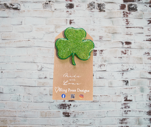 A handmade glitter badge reel with an interchangeable top, featuring a retractable cord and secure clip, perfect for adding sparkle and personality to work attire.