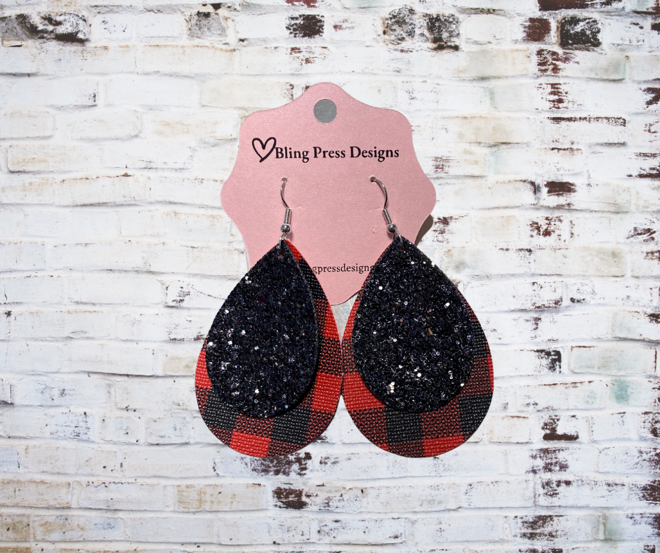 Black glitter and red plaid pattern faux leather dangle earrings, 2.5 inches in length, with lightweight design and nickel-free, hypoallergenic backs.