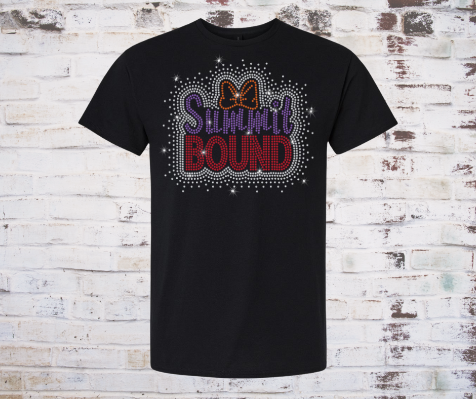 Black t-shirt with 'SUMMit BOUND' rhinestone text and bow design on a rustic wooden background