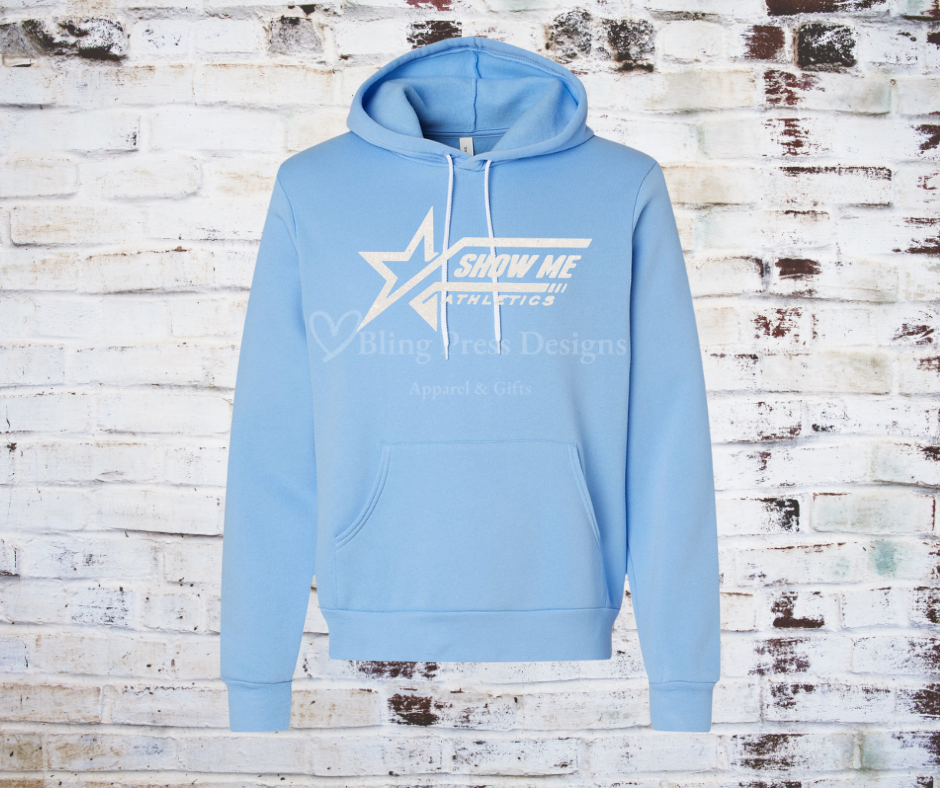 A carolina blue soft and cozy hoodie featuring a white glitter "Show Me" logo, designed with a relaxed fit, front pocket, and adjustable drawstring hood. 