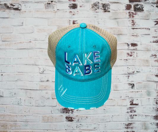 A stylish trucker hat with "Lake Babe" embroidered on the front, featuring a curved brim, breathable mesh back, and adjustable velcro closure, perfect for lake days and outdoor adventures.