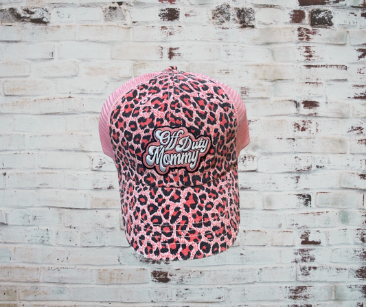  A pink leopard print trucker hat with "Mom Off Duty" embroidered on the front, featuring a curved brim, breathable mesh back, and adjustable snapback closure for a stylish and comfortable fit.