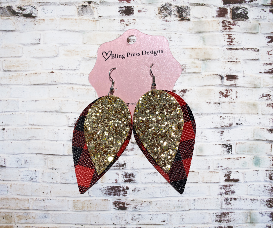 Tear drop shaped Faux leather stacked gold glitter and red plaid dangle earrings, featuring layered faux leather with a shimmering gold glitter finish and a contrasting plaid pattern.