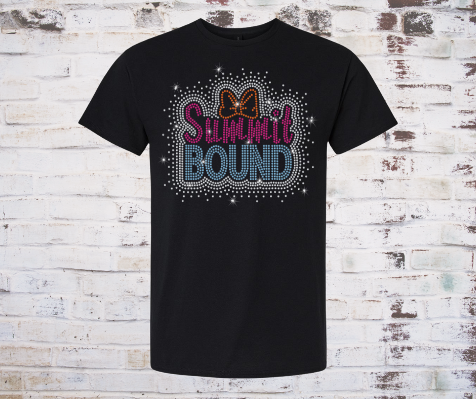 Black t-shirt with 'SUMMit BOUND' rhinestone text and bow design on a rustic wooden background