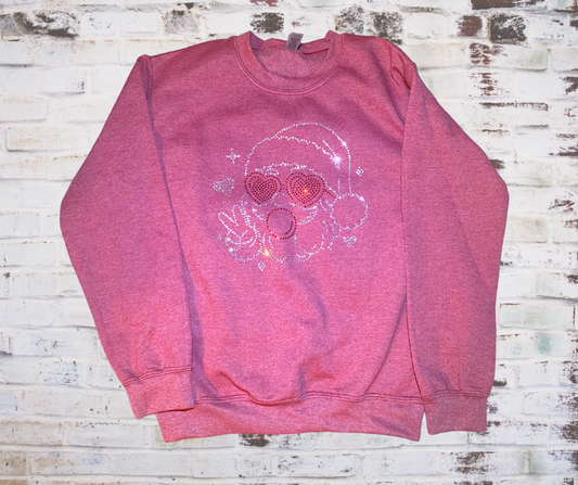 Rhinestone Santa sweatshirt featuring Santa wearing heart-shaped sunglasses and blowing a pink bubblegum bubble; sparkling rhinestone details add festive shimmer.