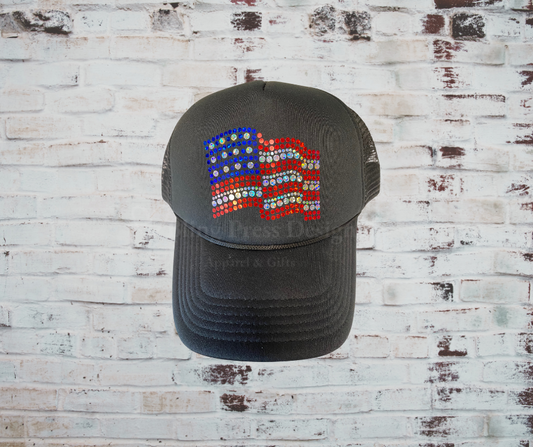  A stylish black trucker hat featuring a sparkling rhinestone American flag design, a curved brim, breathable mesh back, and an adjustable snapback closure, perfect for patriotic celebrations and everyday wear.