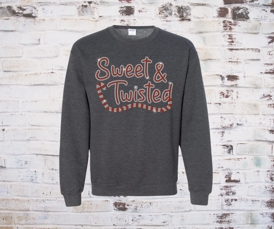 Gray sweatshirt with 'Sweet & Twisted' rhinestone text on a rustic wooden background
