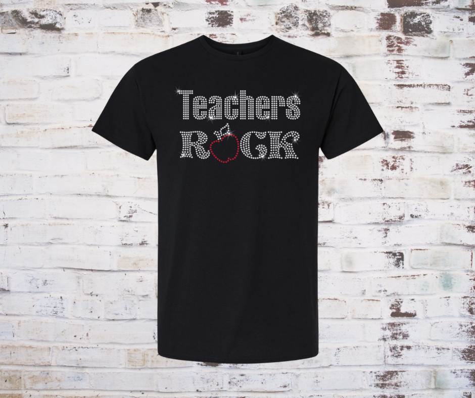 Black t-shirt with 'Teachers Rock' rhinestone with apple text on a rustic wooden background