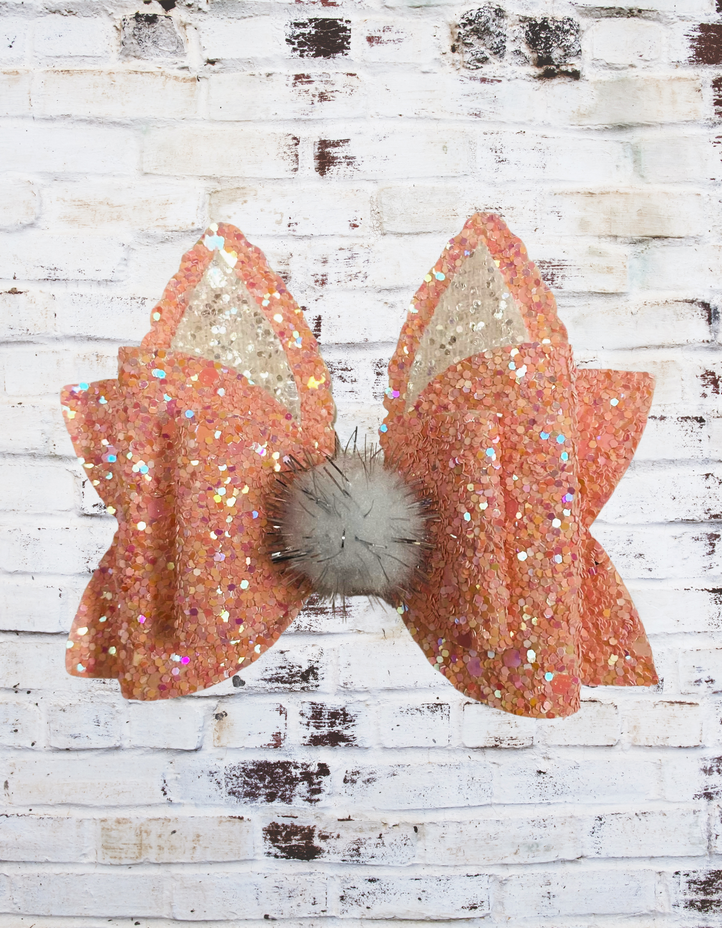 A peach glitter bunny hair bow with a sparkling finish, securely attached to an aligator clip, perfect for Easter outfits and festive hairstyles