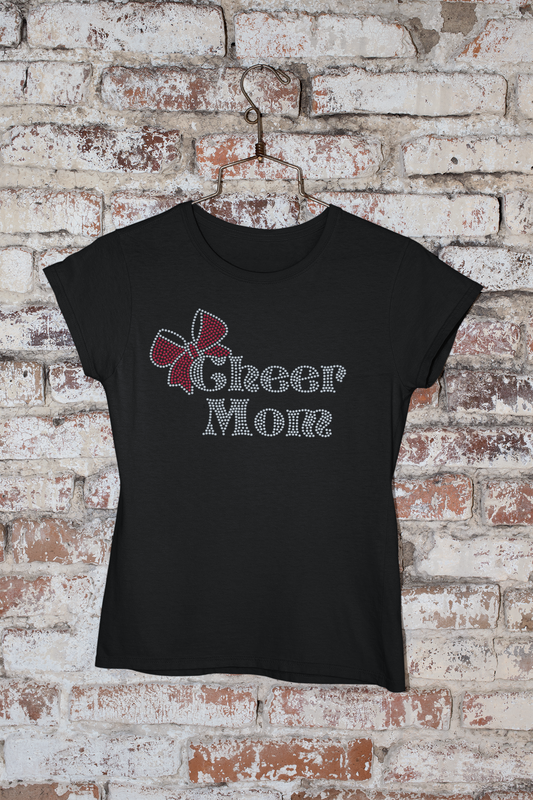 A 'Cheer Mom' rhinestone design with a bow accent on a soft tee, featuring sparkling rhinestones that highlight the text."